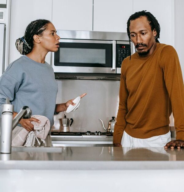 A couple engaged in a heated argument in their kitchen, illustrating relationship conflict over unreasonable demands.