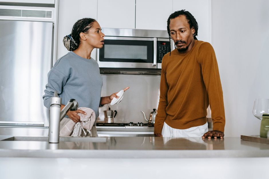 A couple engaged in a heated argument in their kitchen, illustrating relationship conflict over unreasonable demands.