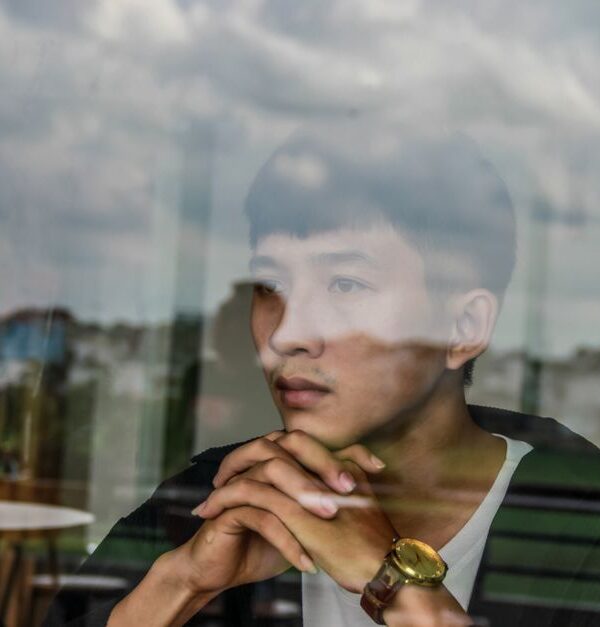 A man lost in thought, gazing out a window as he reminisces about women from his past.