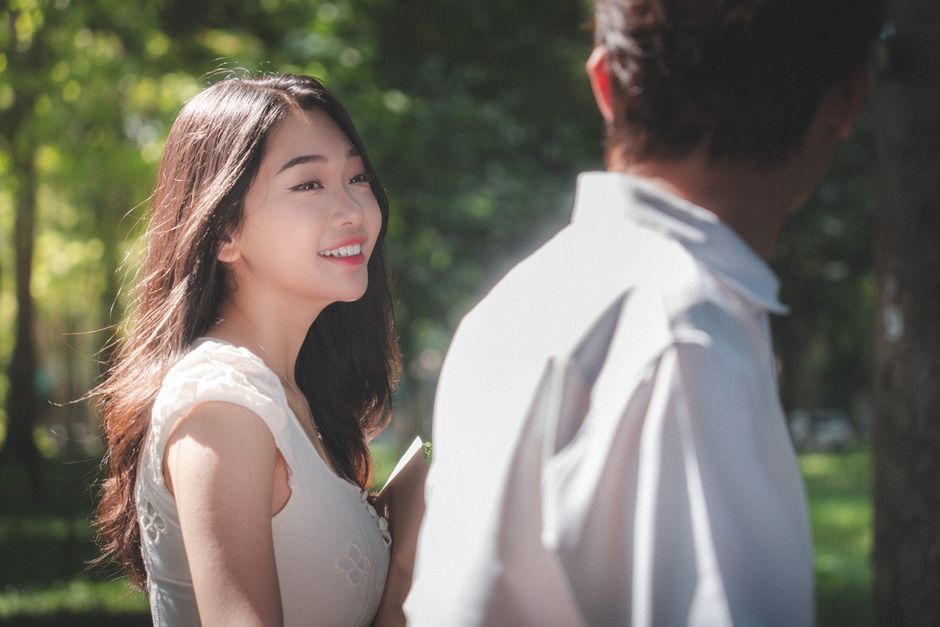 A woman gazes happily at a man, hinting at the subtle signs of hidden affection in a budding relationship.