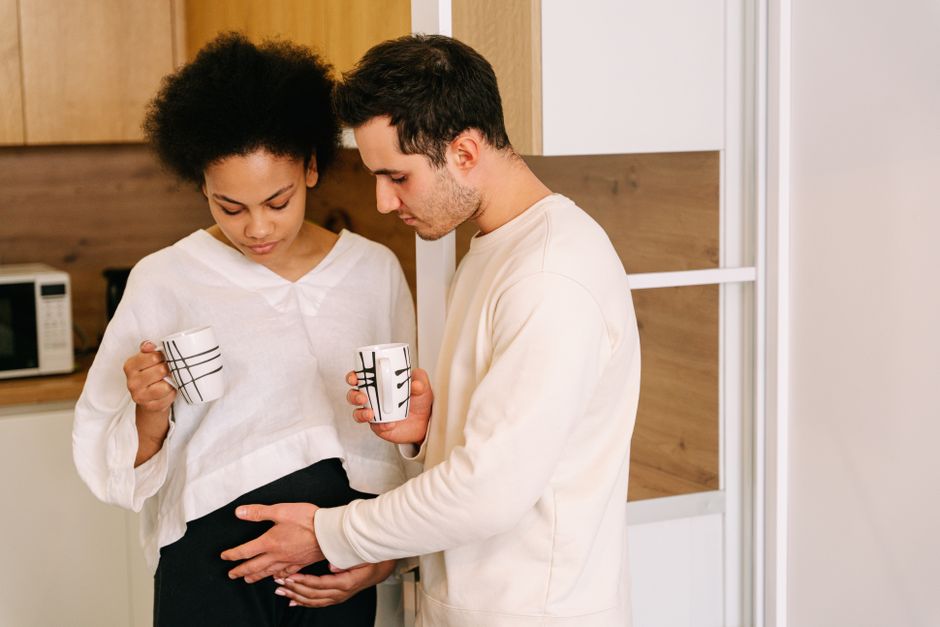 A caring man gently touches his pregnant partner's belly, showing one of the small things women secretly wish men would do more often.