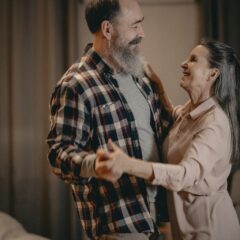 A happy couple dancing together in their living room