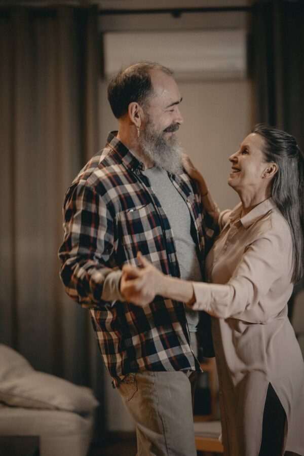 A happy couple dancing together in their living room