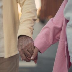 An older couple holding hands on an evening walk