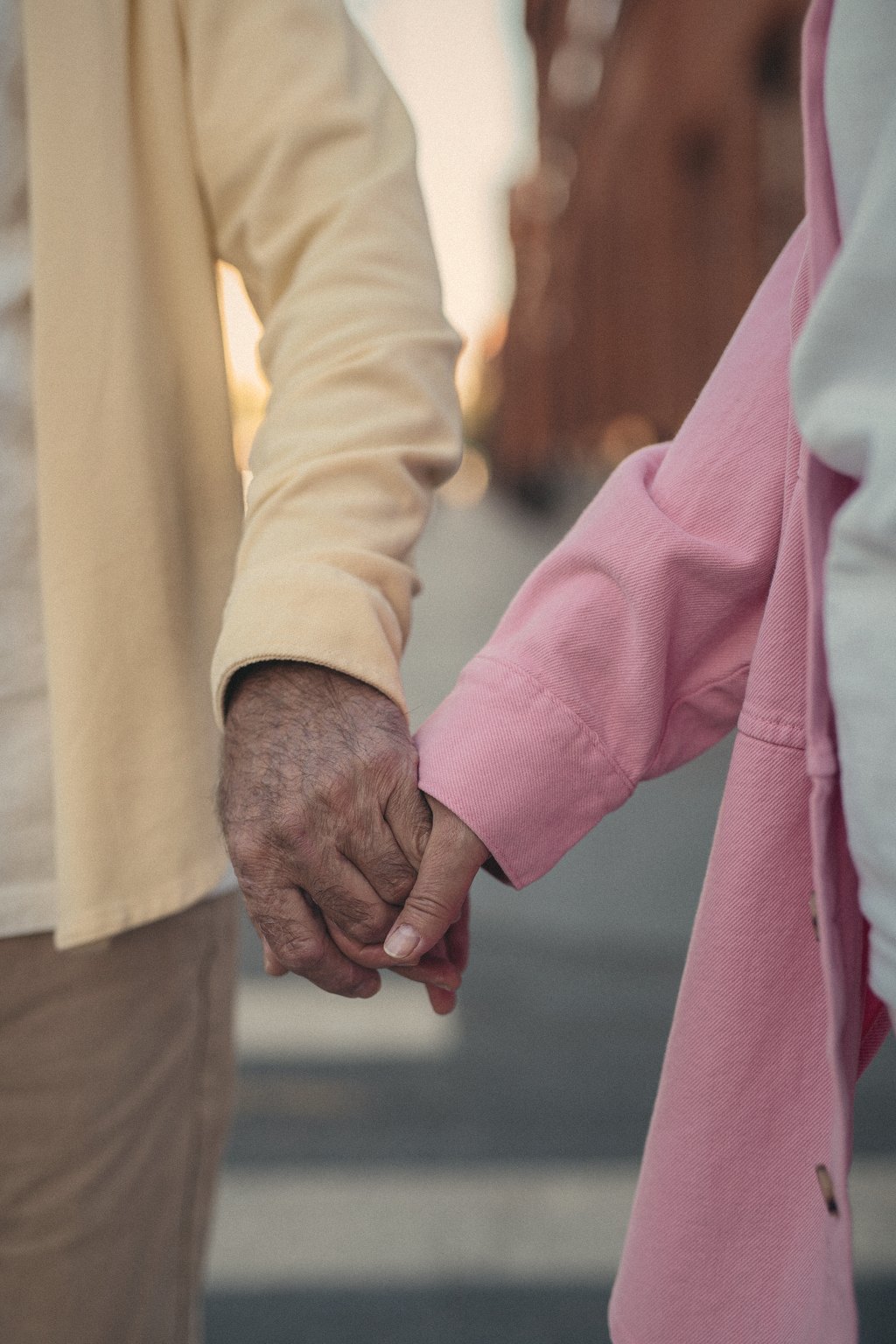 An older couple holding hands on an evening walk
