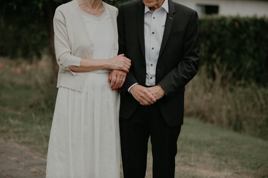 An older married couple standing together, representing the wisdom of long-term marriage experience.