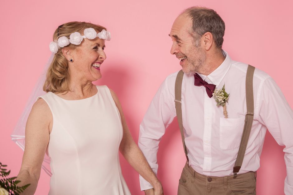 A mature bride and groom share a laugh together on their wedding day, embodying the joy of finding a partner who laughs at the same things.