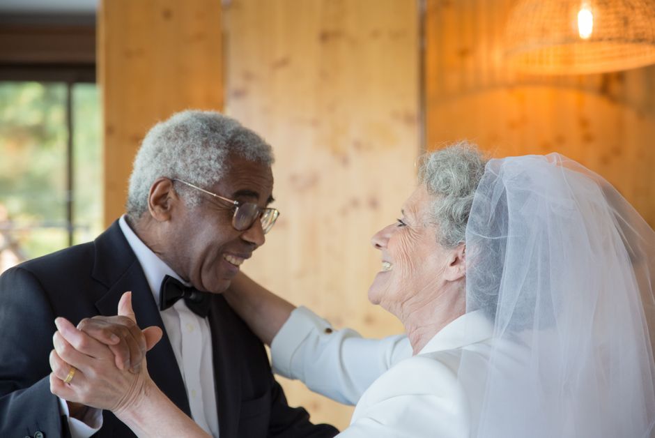 An older bride and groom share a joyful, loving glance on their wedding day, reflecting the wisdom of marriage after 50.