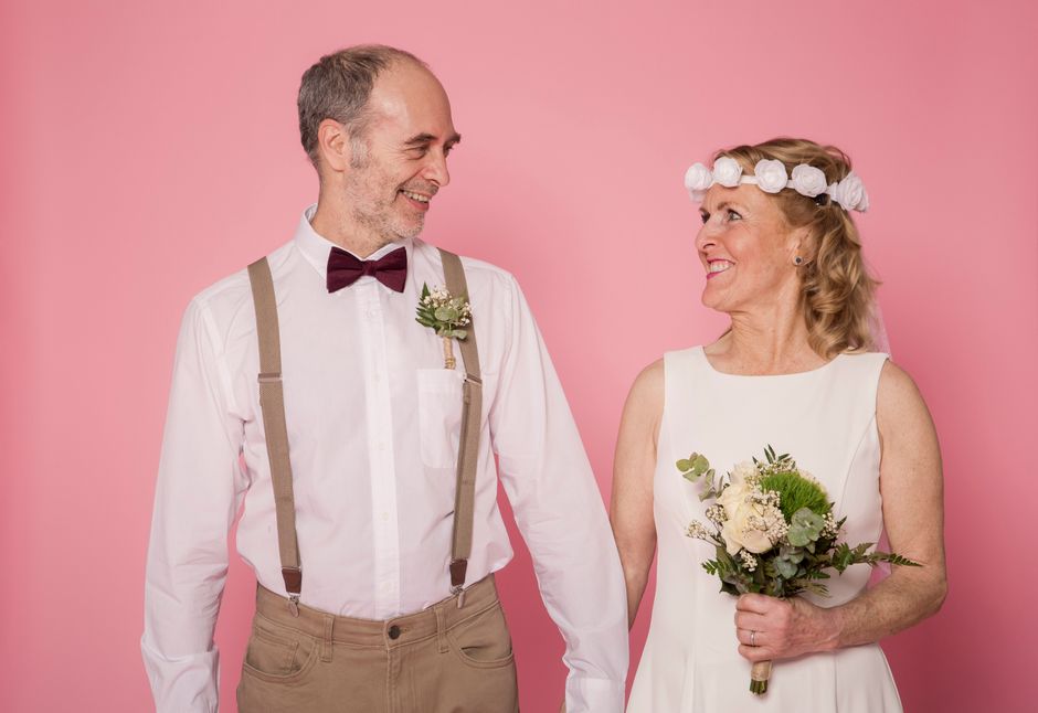 A joyful older couple on their wedding day, looking at each other with love after finding happiness later in life.