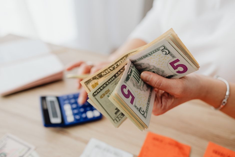 A woman managing her own finances by counting cash, representing financial independence before marriage.