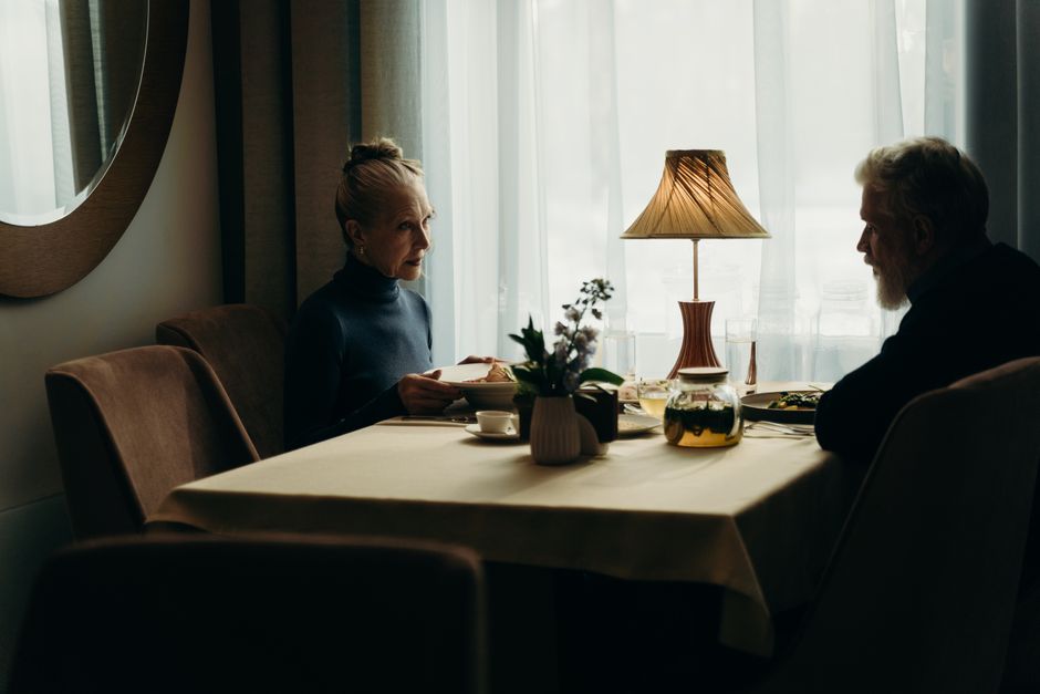 An older couple shares supper together at the table in the evening, just as couples from the '60s have always done.