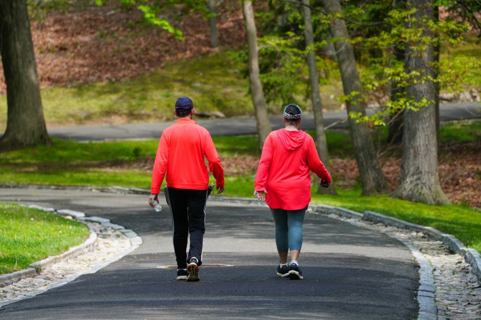 An older couple enjoys their weekly walk together, a simple habit that has kept their marriage strong since the '60s