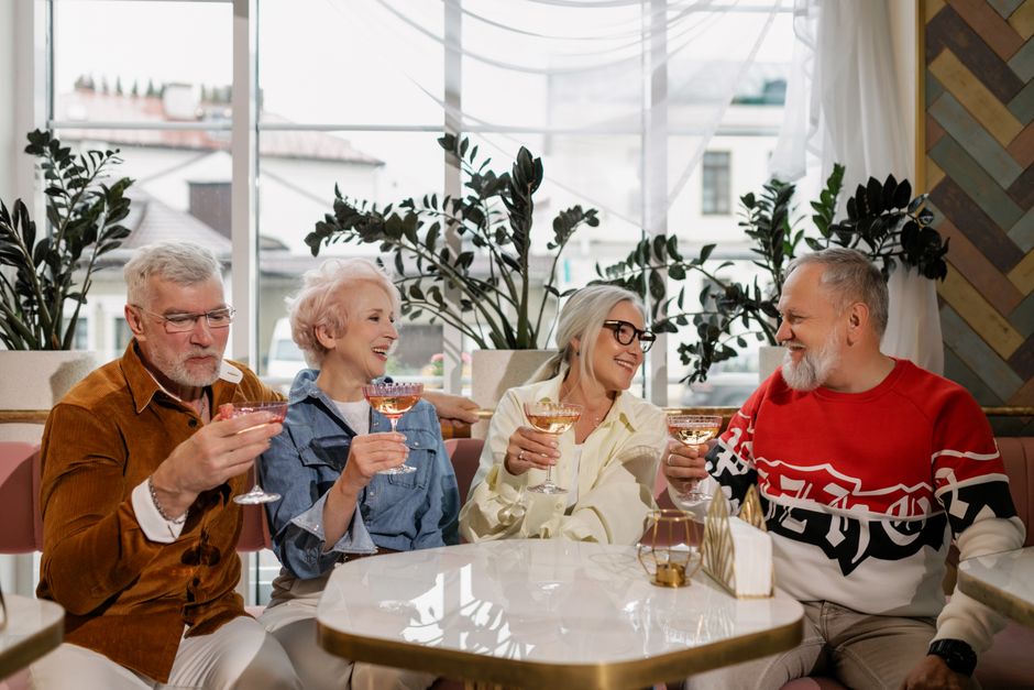 Older couples enjoying drinks together, embodying the habit of spending time with other long-married friends