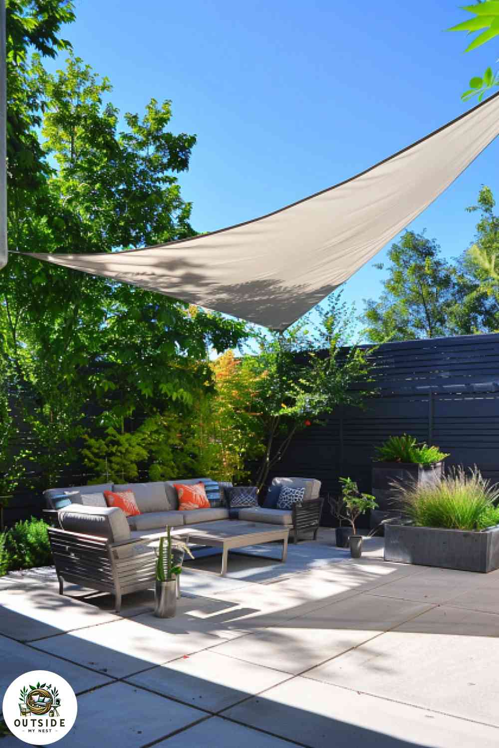 Concrete patio with a shade sail and modern furniture