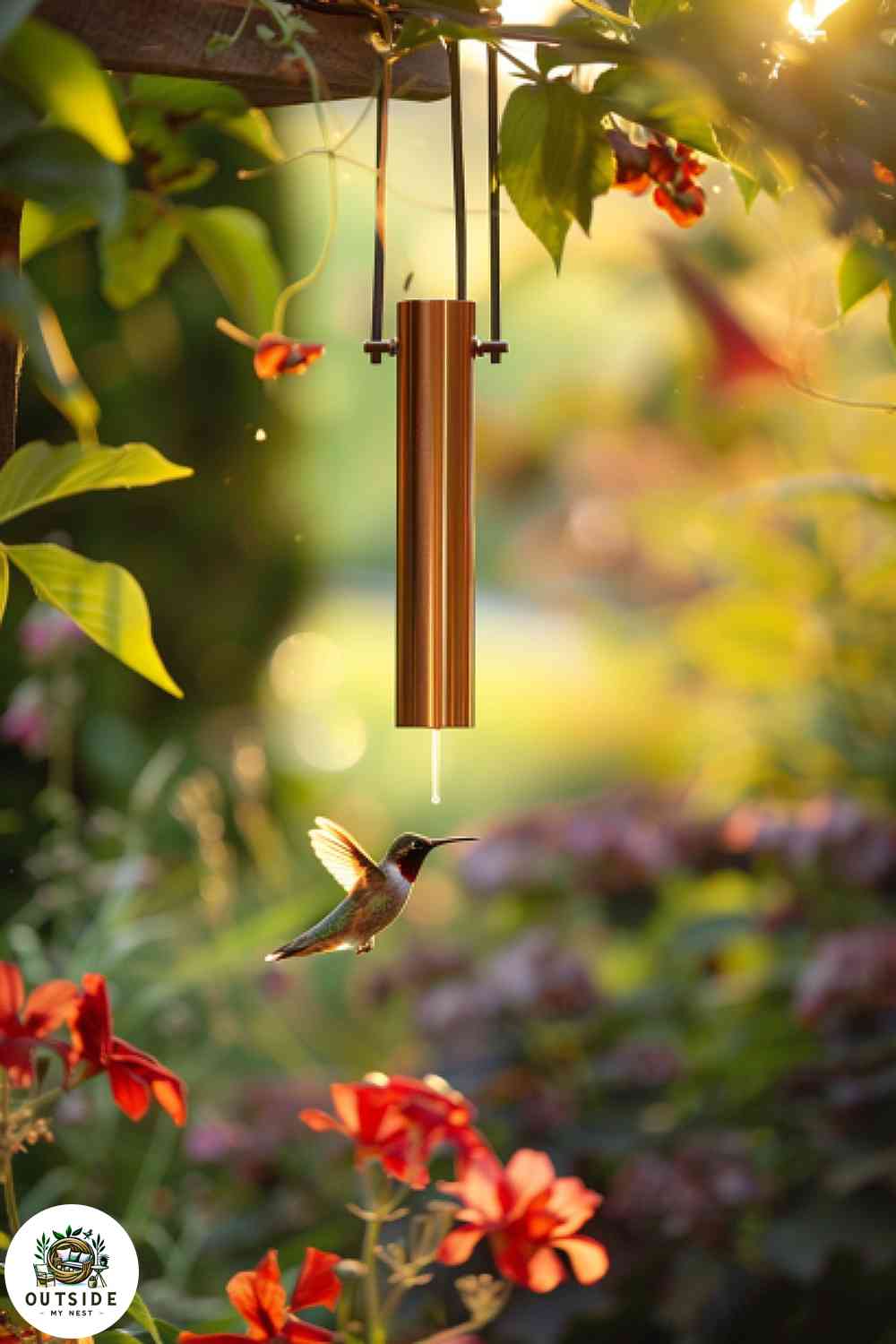 Elegant copper tube hummingbird feeder in a garden