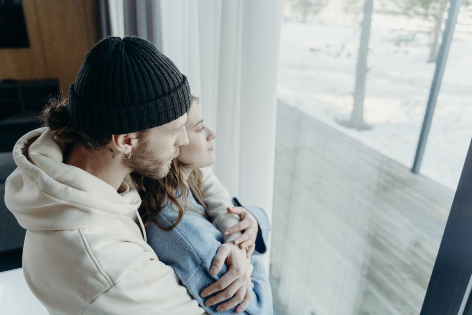 A couple stares silently out the window, their closeness masking an emotional distance that's grown between them.