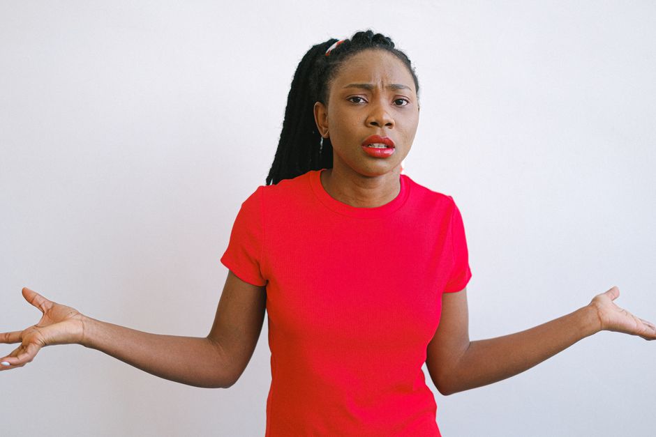 A skeptical woman shrugs with raised palms, demanding proof instead of accepting the truth.