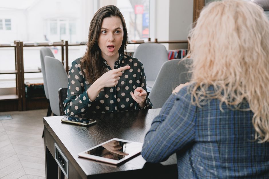A woman passionately recounts a story, pointing accusingly as she describes someone from her past as the villain.