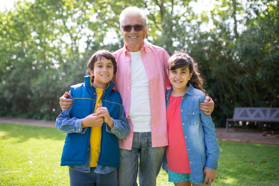 A grandfather embraces his grandchildren affectionately, reflecting the trust and closeness men hope to have with their grandkids.