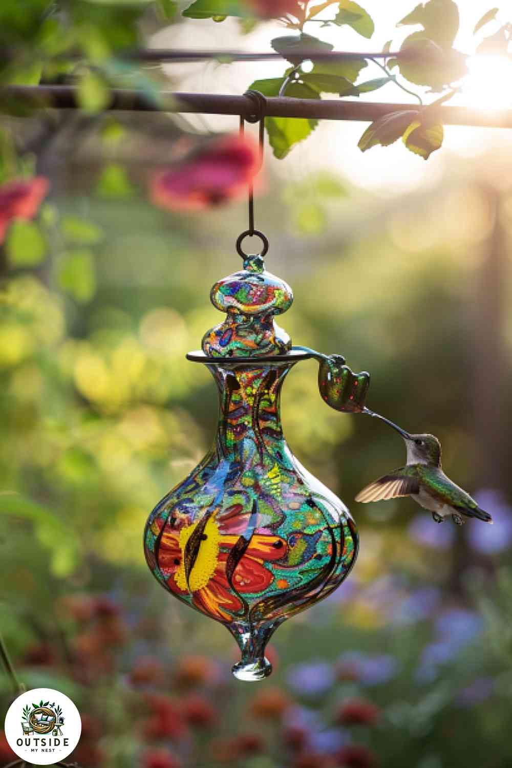 Unique hand-blown glass hummingbird feeder in a garden