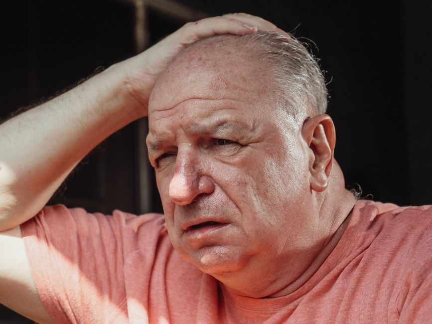 An older man looks troubled as he silently contemplates the reality of aging.