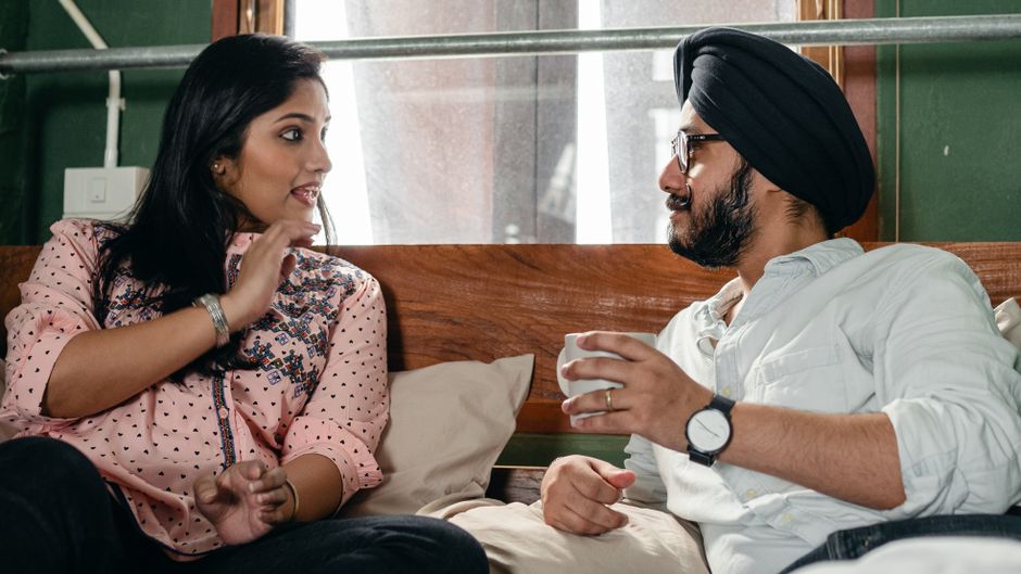 A wife and husband sit close together, truly listening and engaging as she shares her thoughts with him.