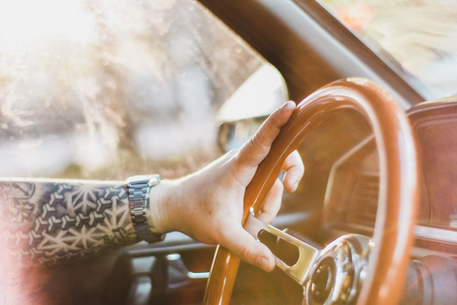 A man gripping the steering wheel as he settles into the car, the start of his classic "almost there" excuse.