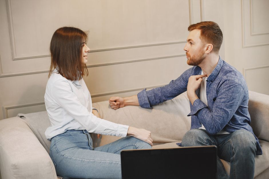 A man openly communicates his feelings to a woman during a heartfelt conversation on the couch.