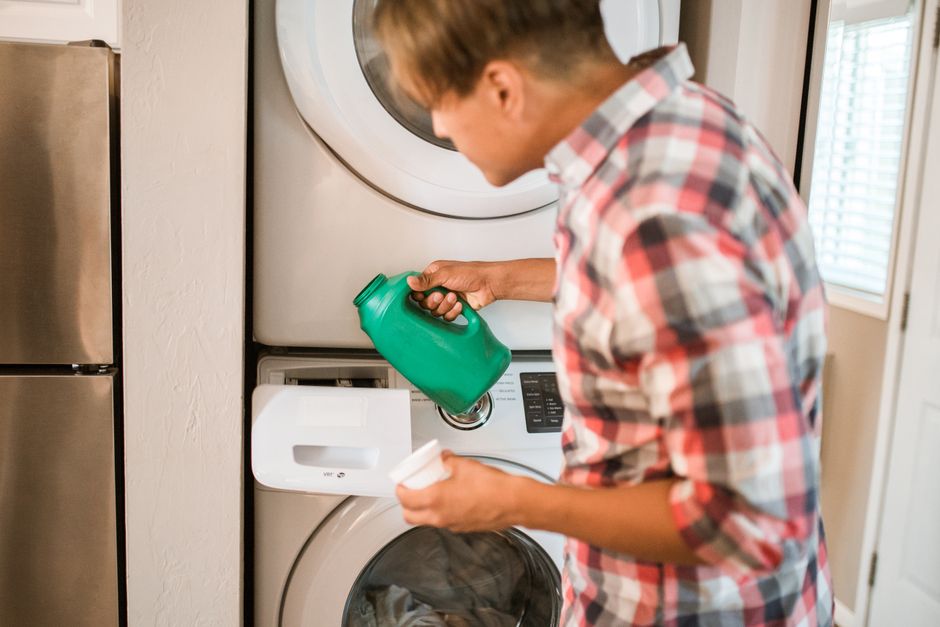 A man proactively does his own laundry, handling his household task without being reminded.