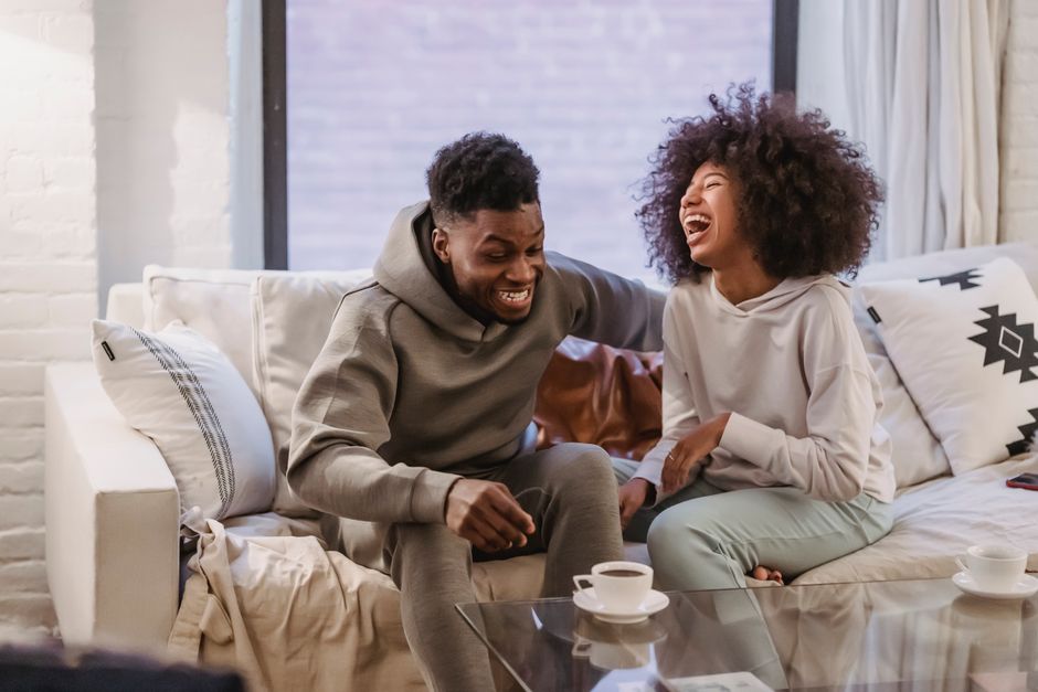 A man gazes at the woman as she bursts into laughter, a sign he might secretly like her