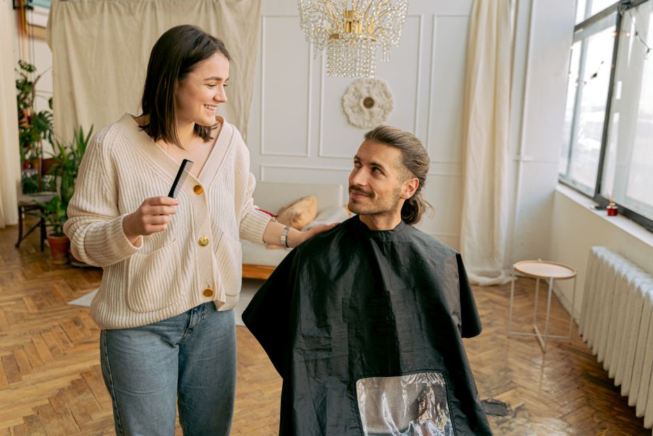 A man notices a woman's attentive gaze as she styles his hair, a small sign he may secretly like her.