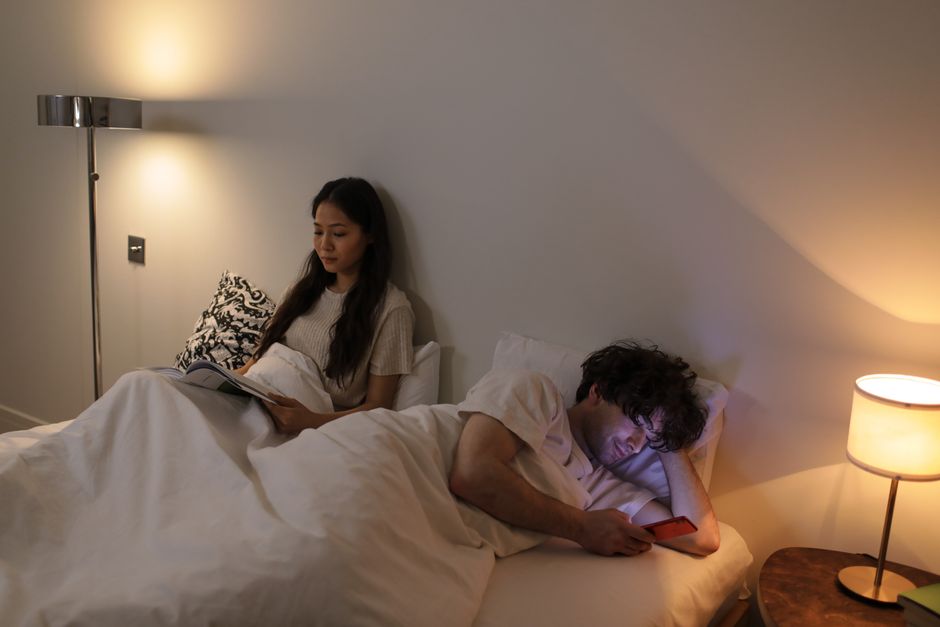 A man stays glued to his phone in bed instead of giving his partner attention when she's right beside him.