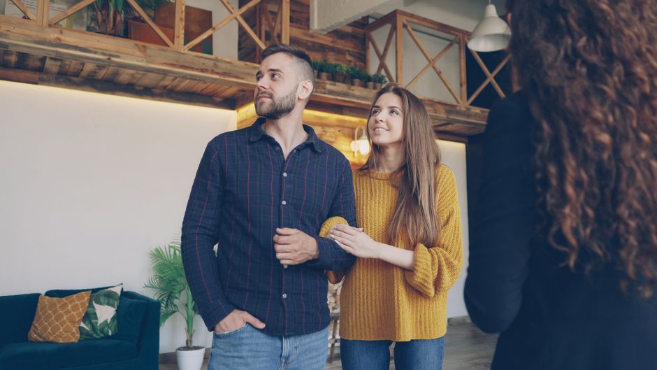A couple stands close, smiling together, hinting at the subtle affection someone might show when he secretly starts picturing a shared future.