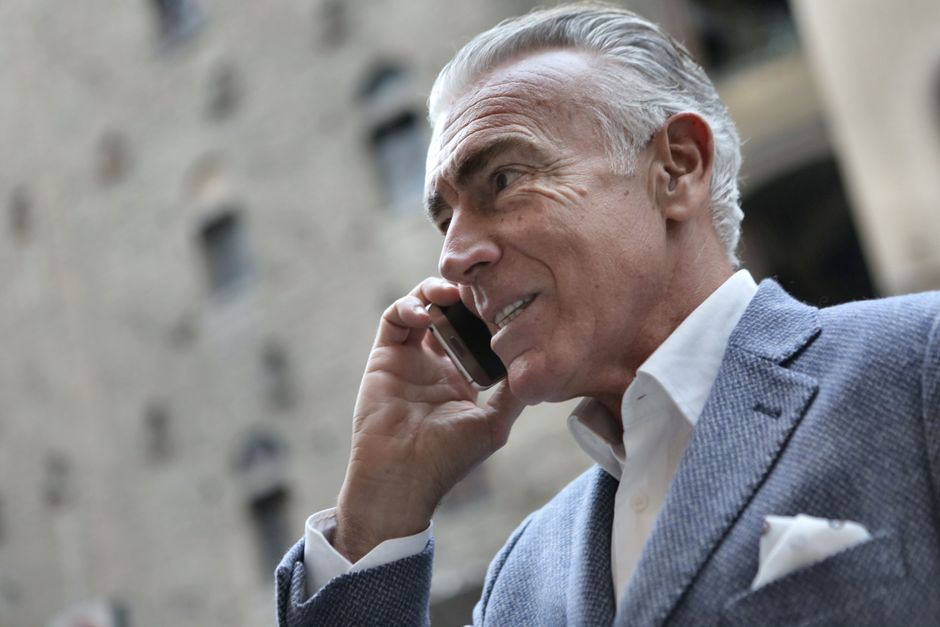 A man over 50 openly communicating on the phone, reflecting the idea of expressing feelings rather than staying silent.