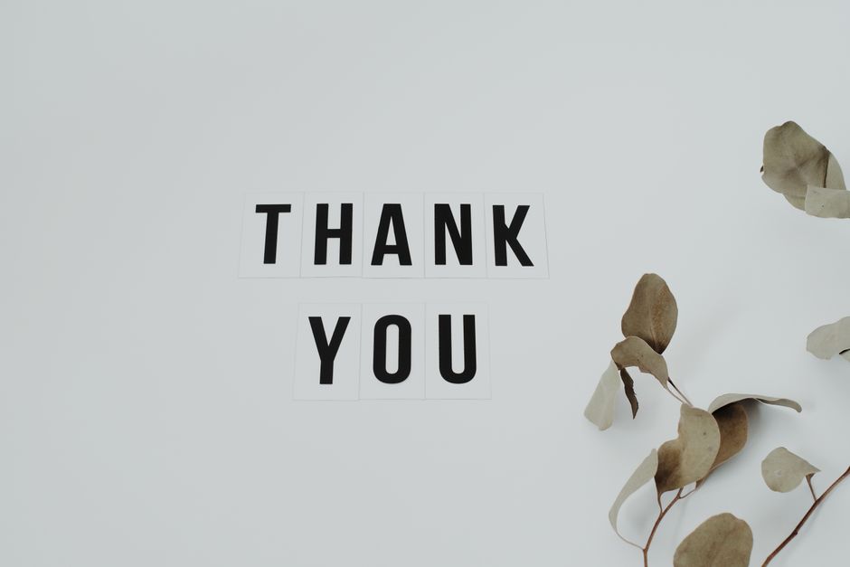 Letter tiles spelling "thank you" next to dried leaves, symbolizing the importance of expressing gratitude out loud in relationships.
