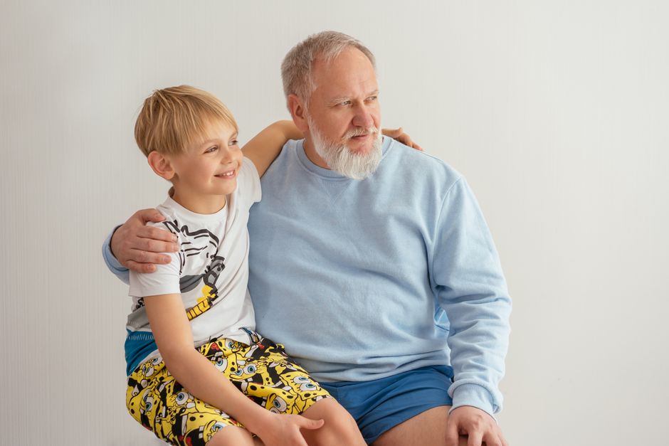 A grandfather embraces his grandson affectionately, reflecting the loyalty and love that defines being a good man for the next generation.