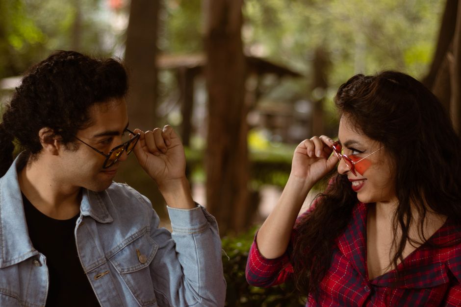 A woman playfully chats with a man, engaging him with a question as a way to spark connection.