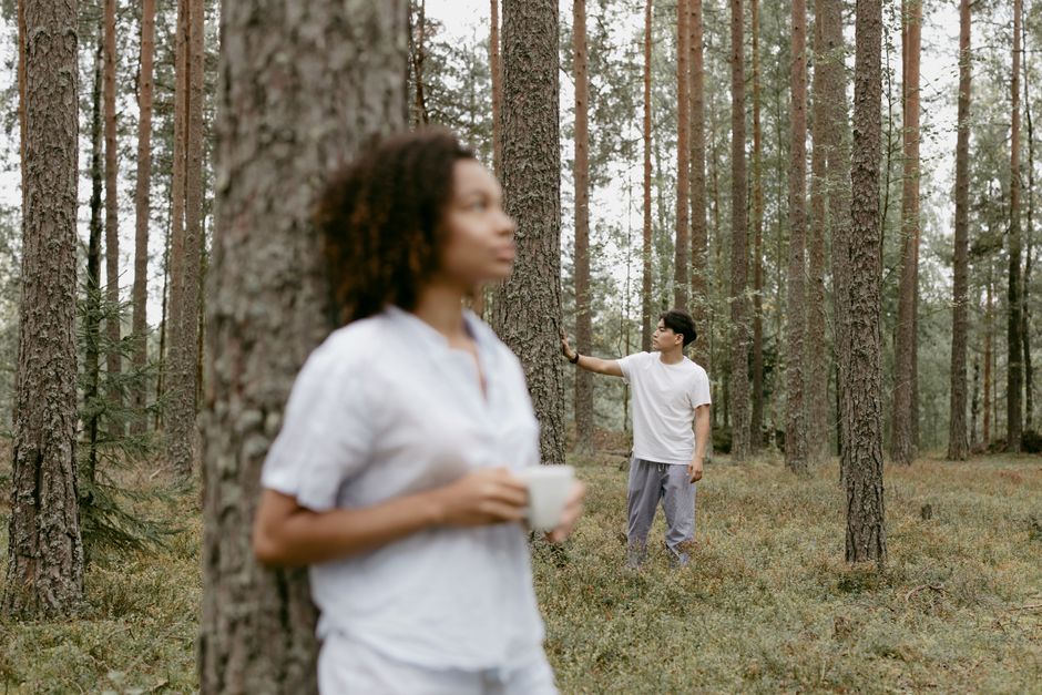 A woman keeps her composure and distance while a man drifts away quietly in the background, illustrating the idea of not chasing when he goes quiet.
