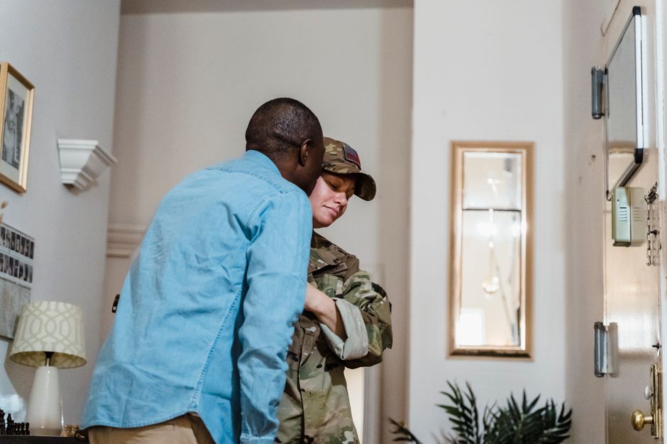 A woman returning home to lovingly embrace the man who missed her, showing up as herself rather than just checking in.