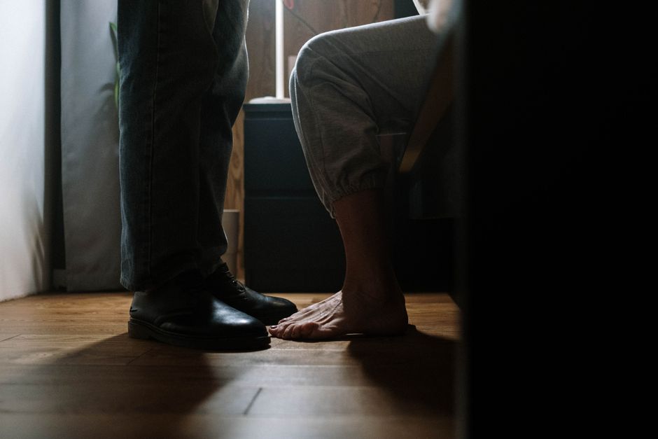 Her bare feet point directly toward him as they stand close together, a subtle sign she's open to him approaching.
